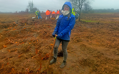 Frau mit Schaufel auf dem Feld